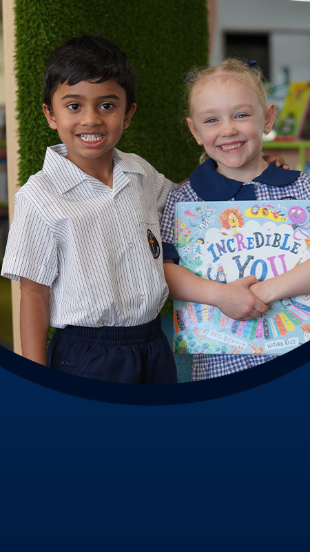 Students holding a book together in the library at St John XXIII College Stanhope Gardens