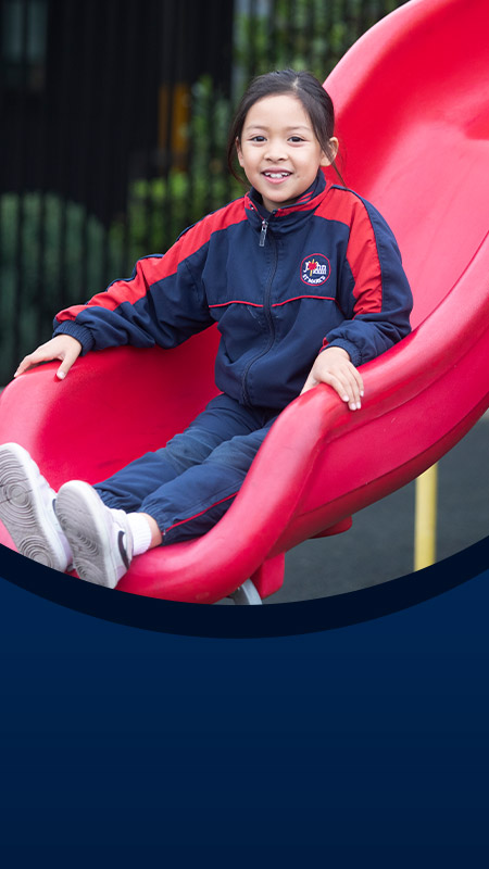 Student sliding down the slide in the playground at St John XXIII College Stanhope Gardens