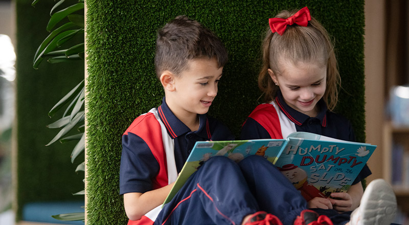 Students reading a book together in the library at St John XXIII College Stanhope Gardens