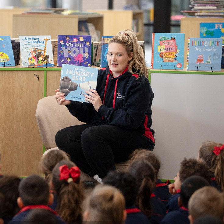 Teacher reading to student in the library at St John XXIII College Stanhope Gardens